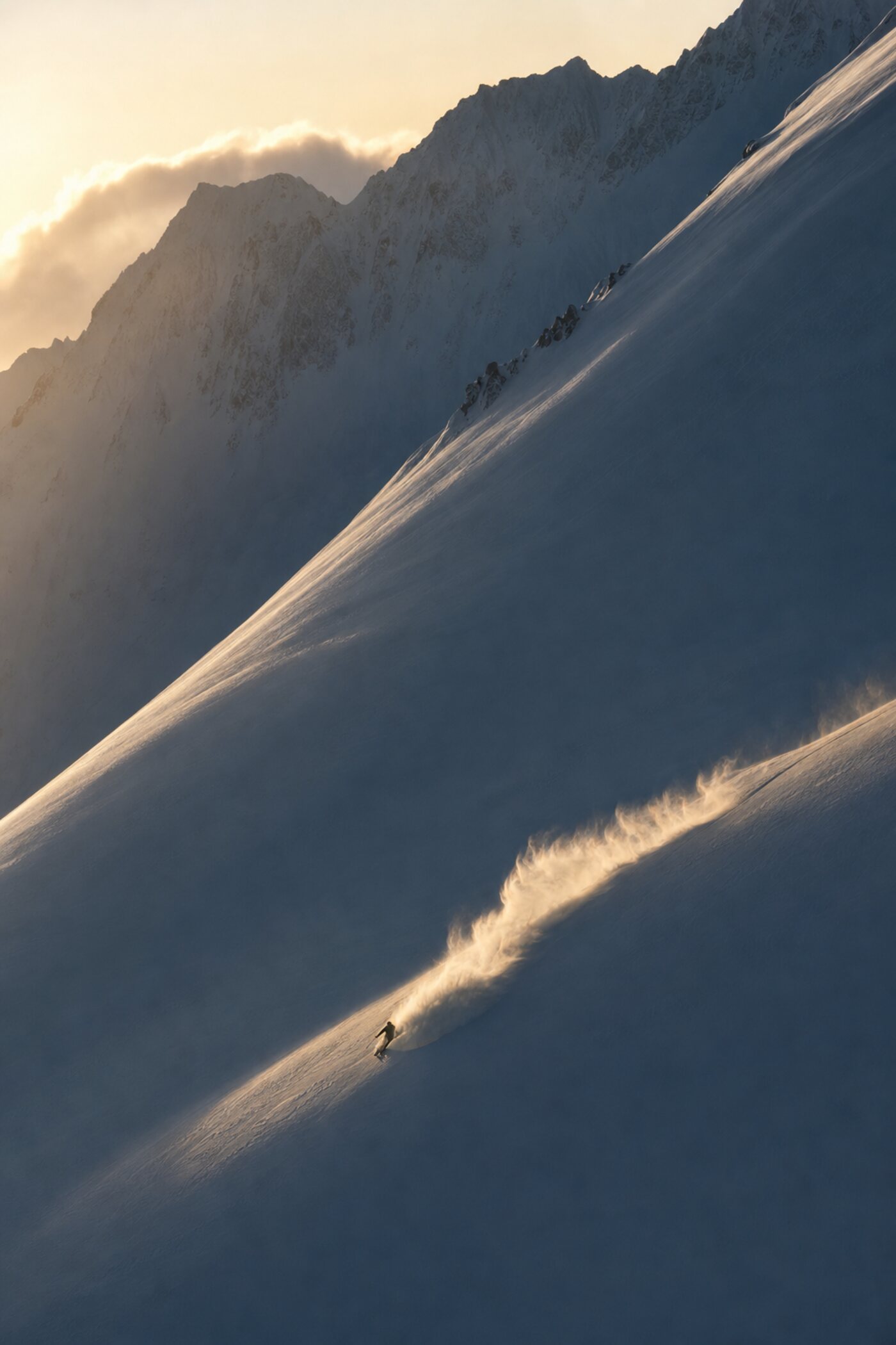 A lone skier drawing the first line of the morning across an empty face